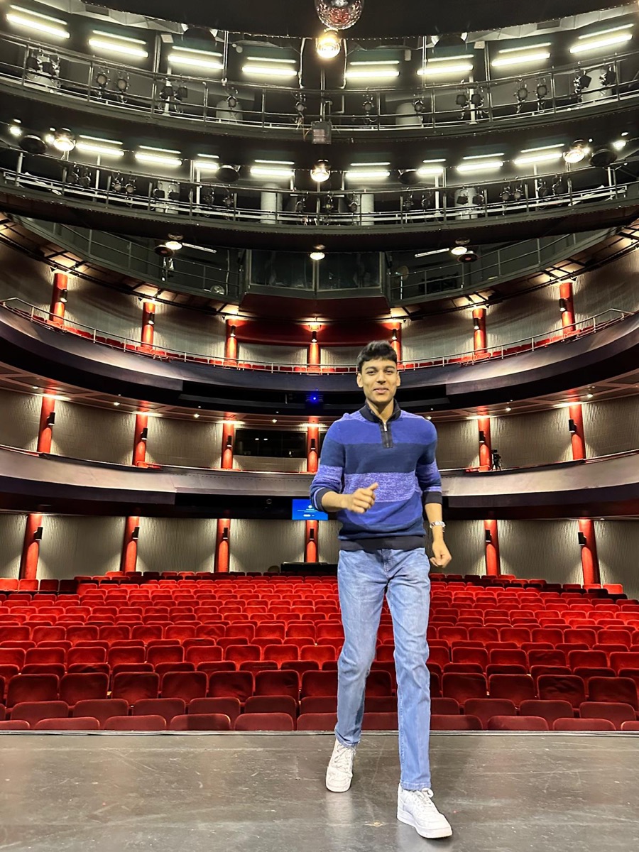 Mahir standing on stage in an empty theatre