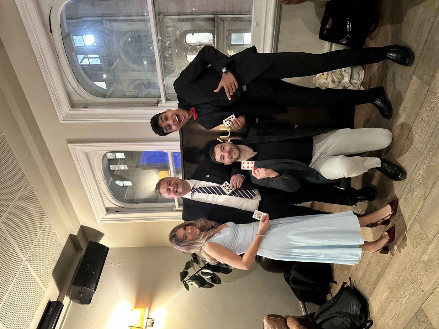 Mahir and guests holding up signed cards at a corporate event