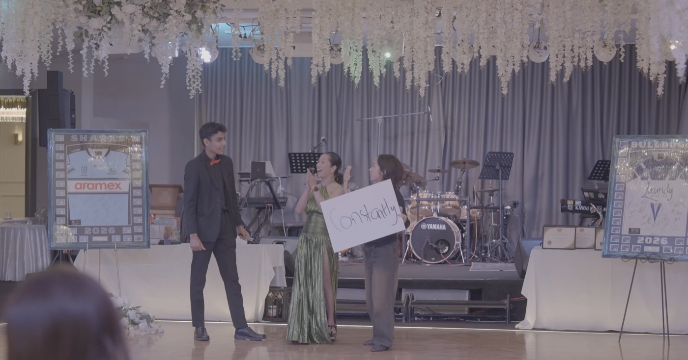 Mahir performing on stage with two guests at a wedding reception